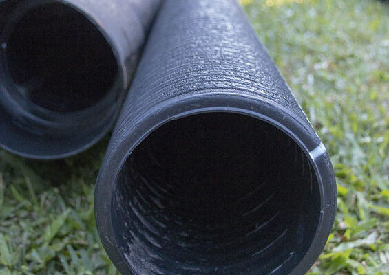 A close up view of a few black filtering water pipes just to channel out water in a french drain